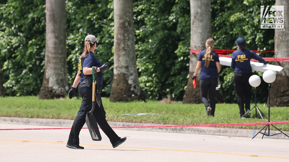 Investigadores del FBI transportan una caja con pruebas desde el perímetro del Trump International Golf Club en West Palm Beach