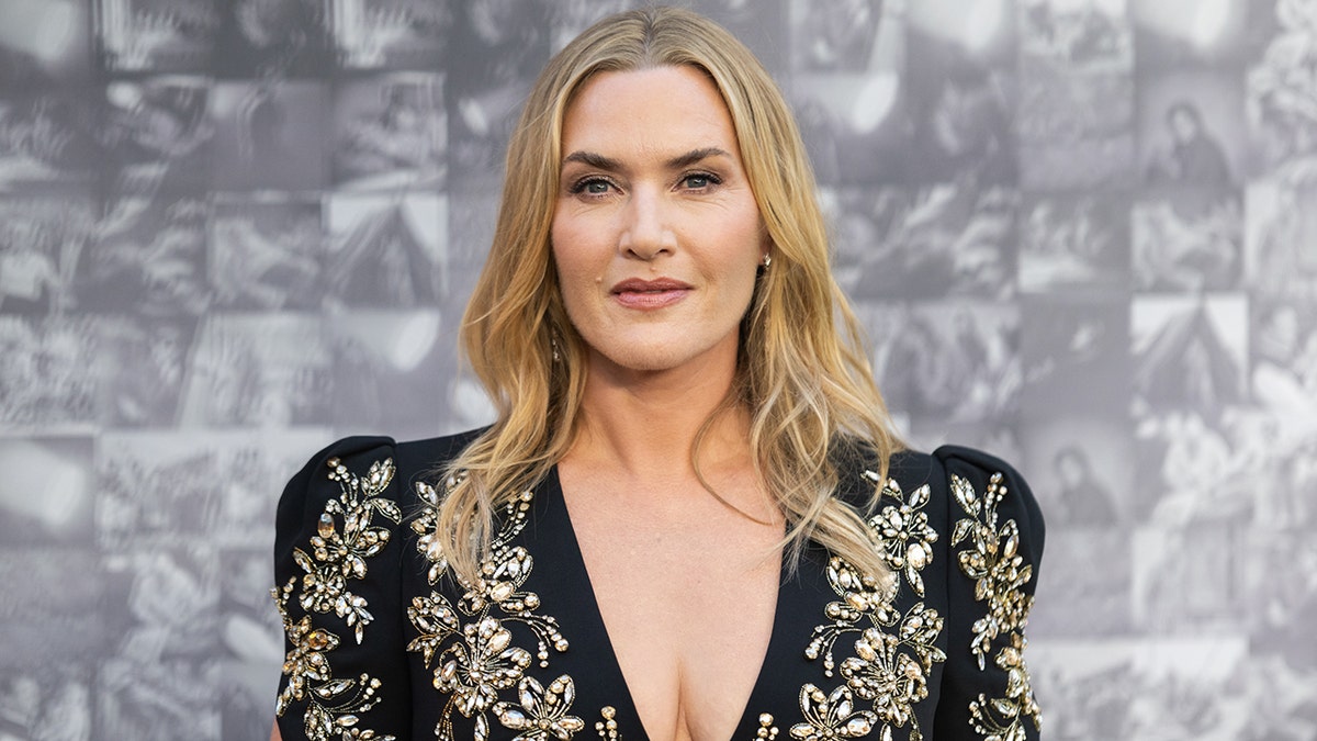 Kate Winslet con un vestido negro con adornos joya