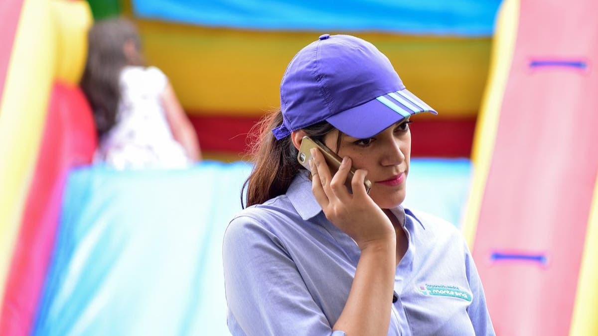 mujer con sombrero morado hablando por teléfono 