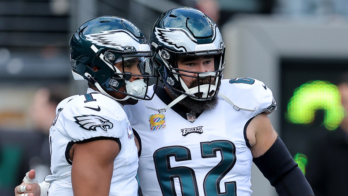 Jalen Hurts and Jason Kelce look at the field