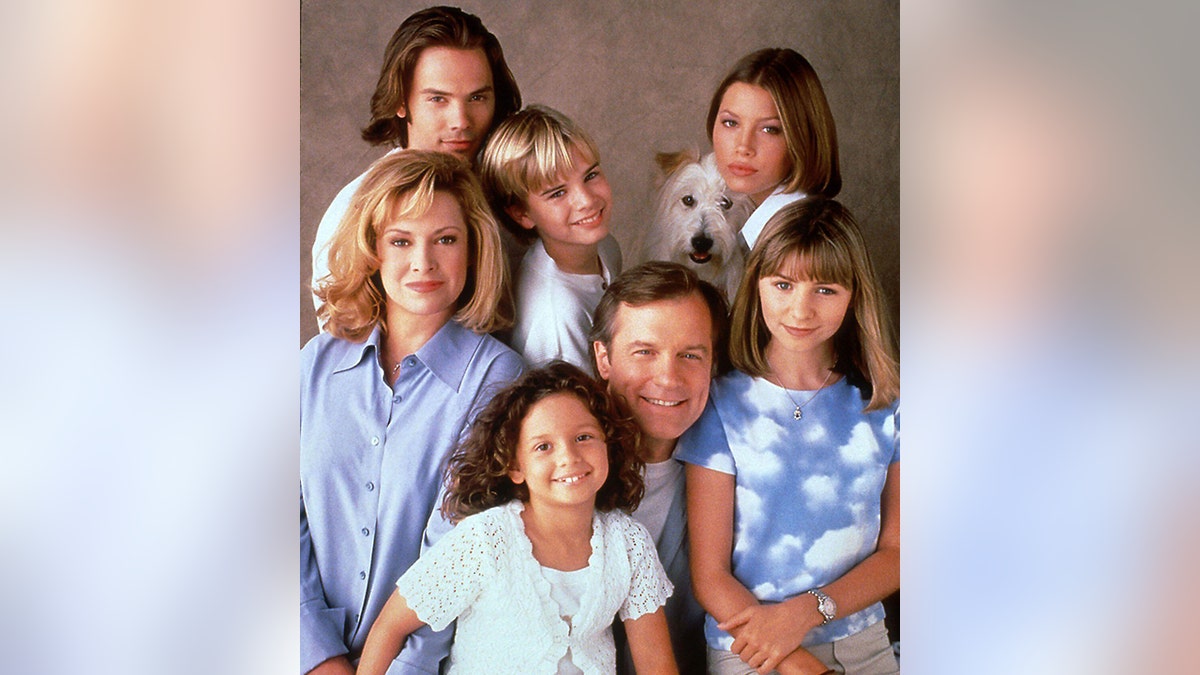 The cast of 7th Heaven, including Stephen Collins, Beverley Mitchell, David Gallagher, Catherine Hicks, Jessica Biel, Barry Watson and Mackenzie Rosman in various shades of blue, pose as characters