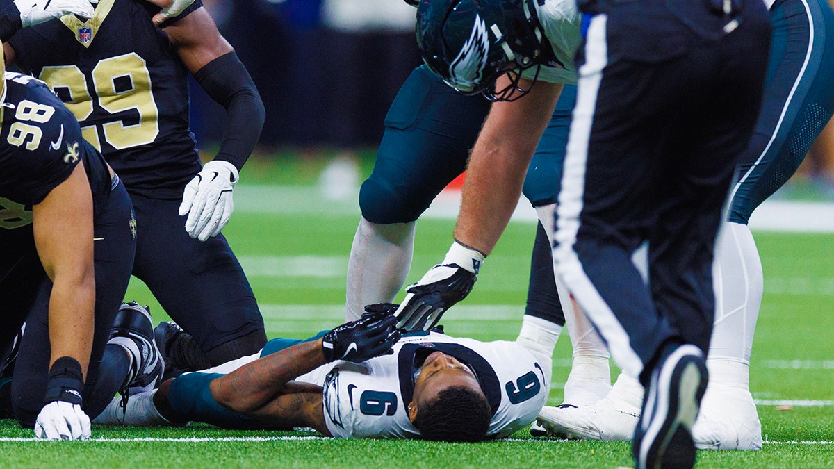 DeVonta Smith lies on grass