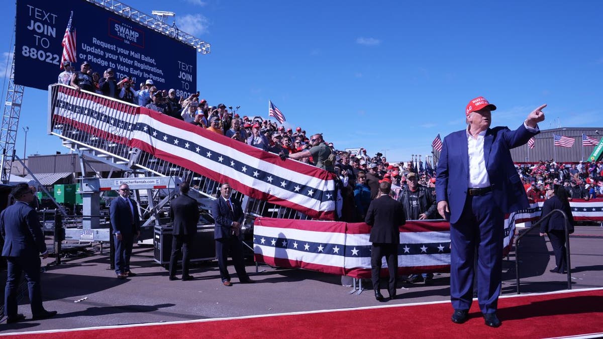 Trump apontando para a multidão