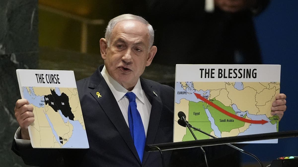 Israeli Prime Minister Benjamin Netanyahu holds signs as he speaks at the 79th session of the United Nations General Assembly on Friday, September 27, 2024.