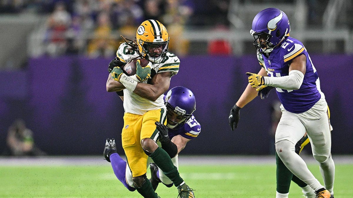 Aaron Jones corre con un balón de fútbol