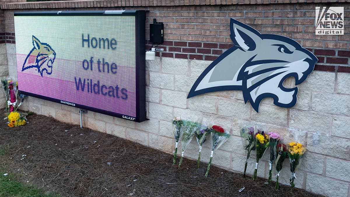 Las flores se sientan contra el letrero de la Escuela Secundaria Apalachee