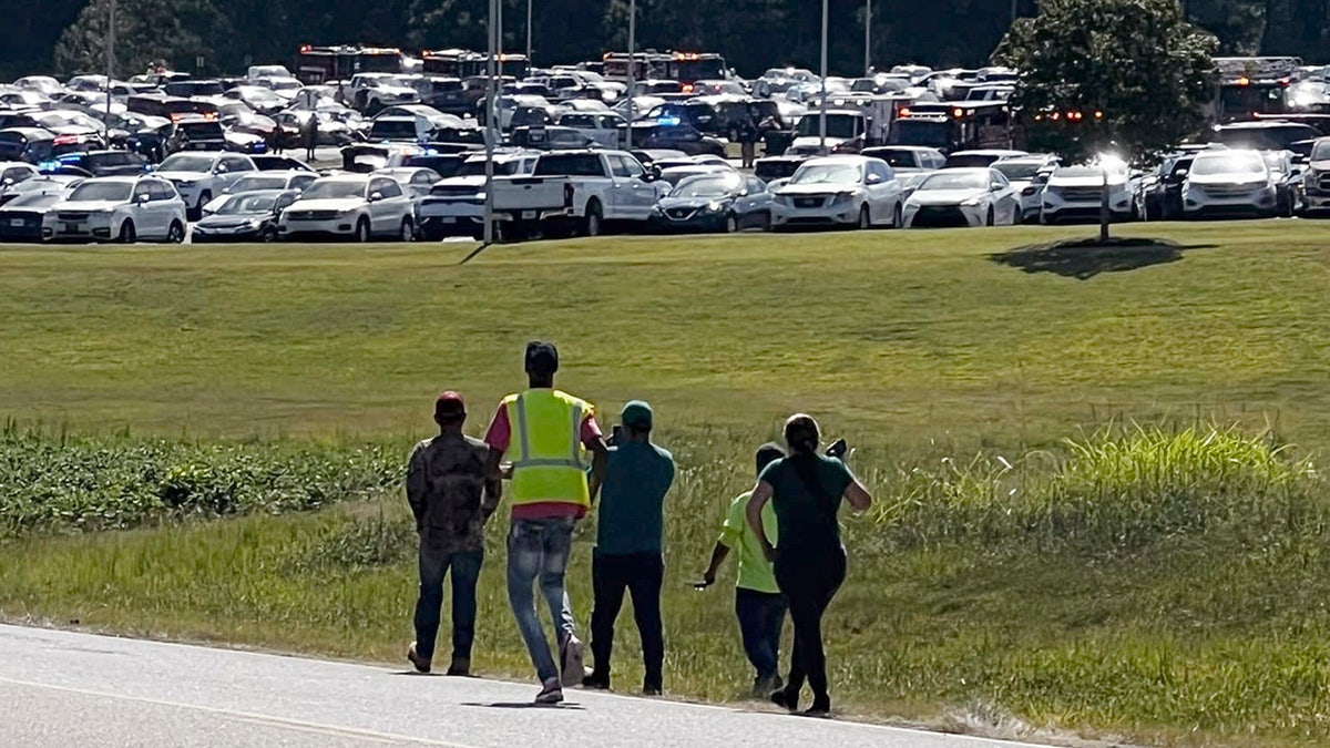 Students are evacuated to the football stadium after the school campus was placed on lockdown at Apalachee High School