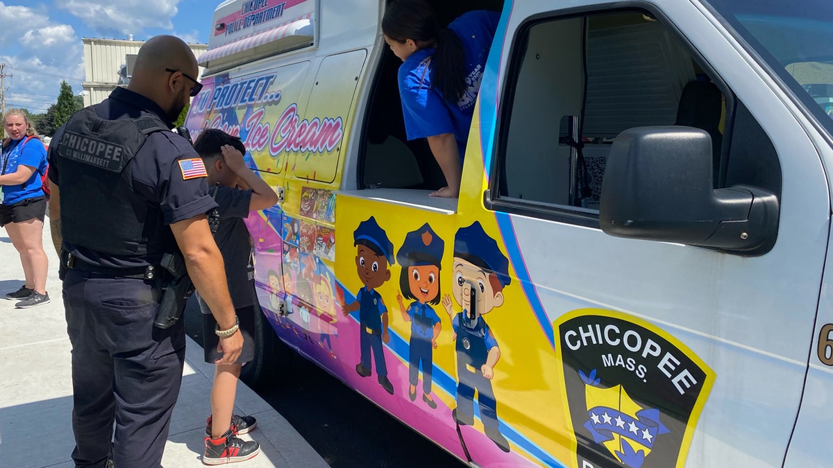 Un niño elige entre varias opciones de helado que se le ofrecen gratuitamente por cortesía del Departamento de Policía de Chicopee.