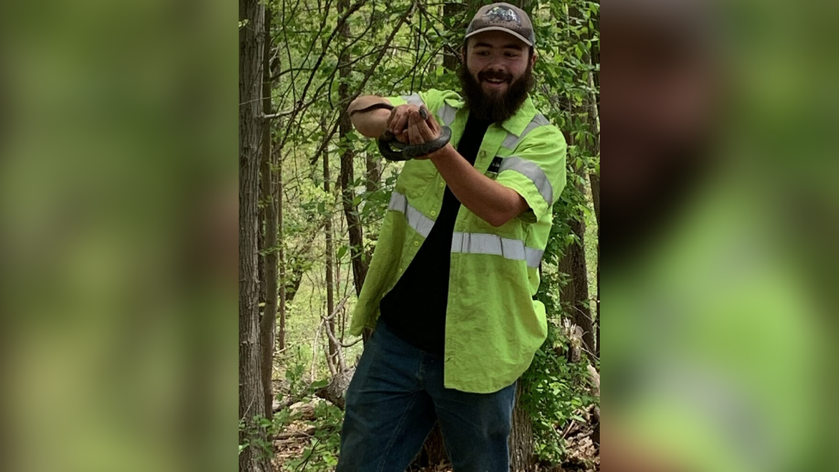 Christian Sluka holds a snake