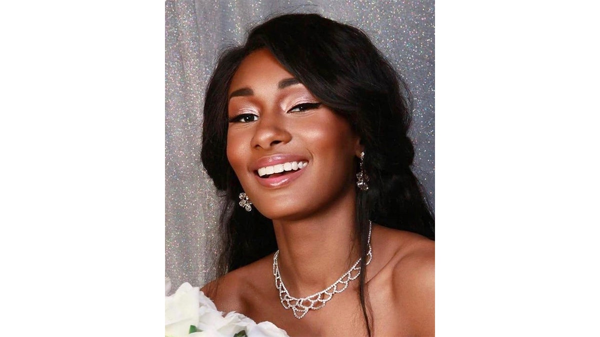 Danielle Hazel smiles while holding a bouquet