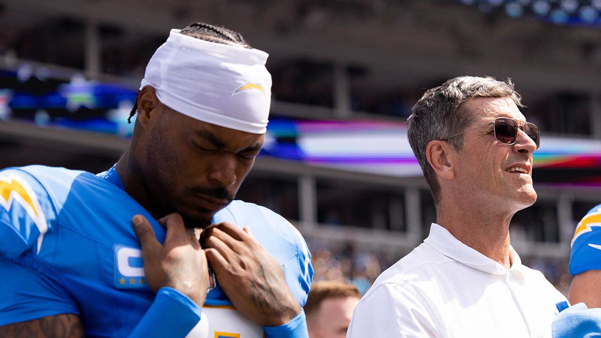 Derwin James y Jim Harbaugh durante el himno nacional