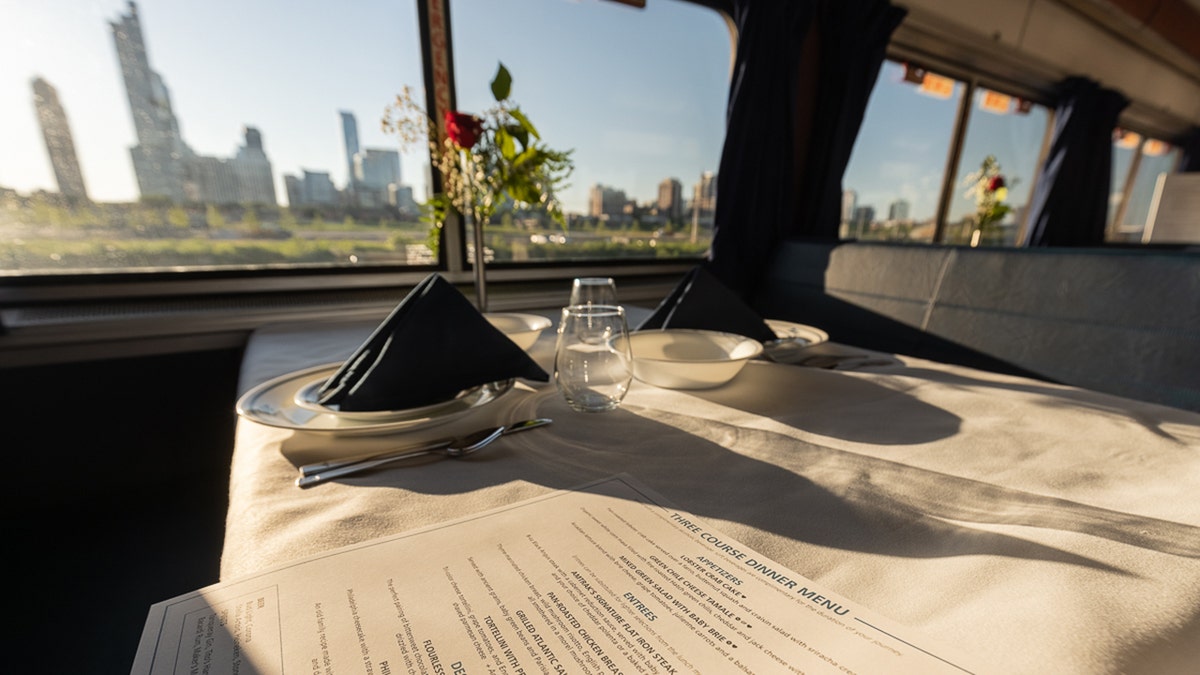 El vagón restaurante de Amtrak con una ciudad al otro lado de la ventana.