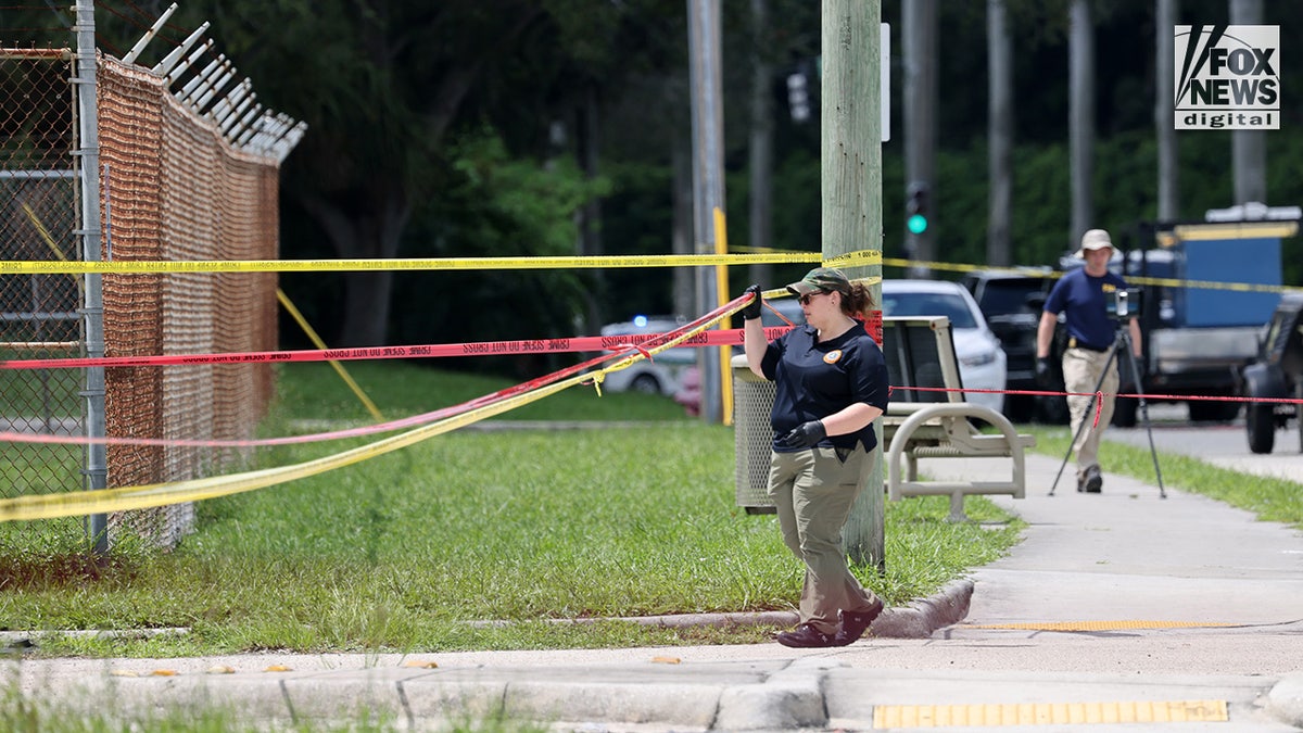 FBI investigators gather evidence from the perimeter of Trump International Golf Club in West Palm Beach