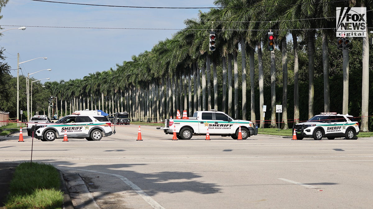 Miembros del Departamento del Sheriff del Condado de Palm Beach patrullan frente al Trump International Golf Club