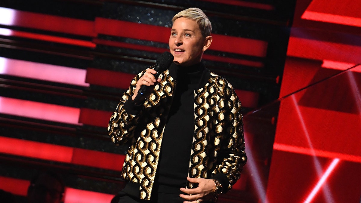 Ellen DeGeneres no palco com microfone na mão