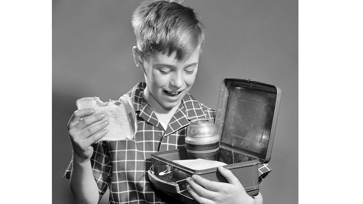 Niño con bocadillo y fiambrera.