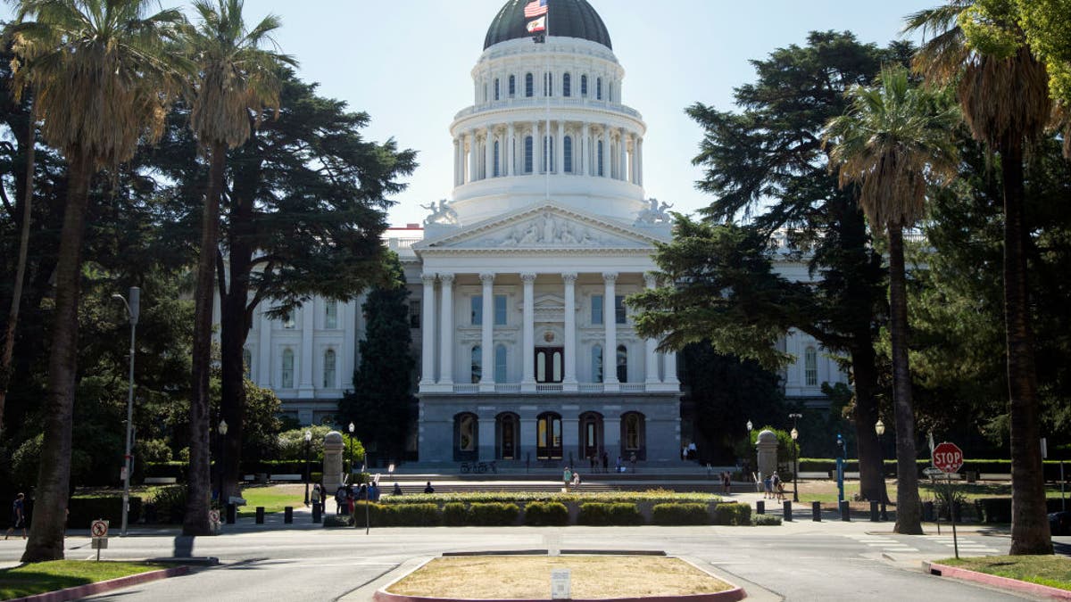 California Capitol on sunny day, framed by palm trees