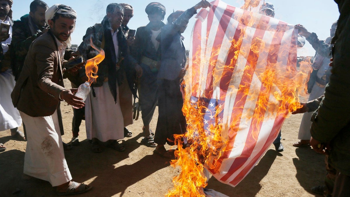 Houthi followers burn the Israeli and American flags during a tribal gathering on January 14, 2024 on the outskirts of Sana'a, Yemen. Houthi followers gathered to protest against the U.S.-U.K. airstrikes on positions in areas under their control.?