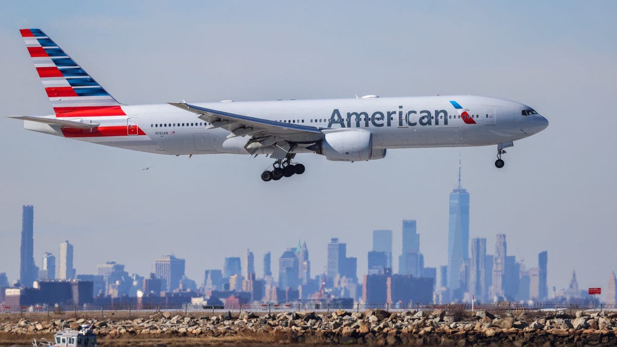 Sebuah jet American Airlines mendarat di Bandara JFK di New York dengan latar belakang cakrawala