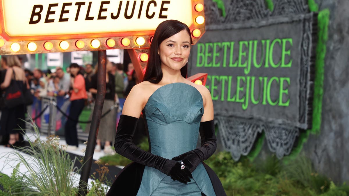 la actriz Jenna Ortega posando en la alfombra del estreno