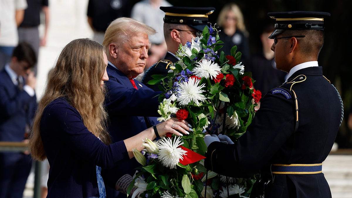 El candidato presidencial republicano, el ex presidente estadounidense Donald Trump, junto a Misty Fuoco, cuya hermana, la sargento Nicole Gee, murió en el atentado de Abbey Gate, en una ceremonia de colocación de coronas en la Tumba del Soldado Desconocido del Cementerio Nacional de Arlington, el 26 de agosto de 2024 en Arlington, Virginia. 