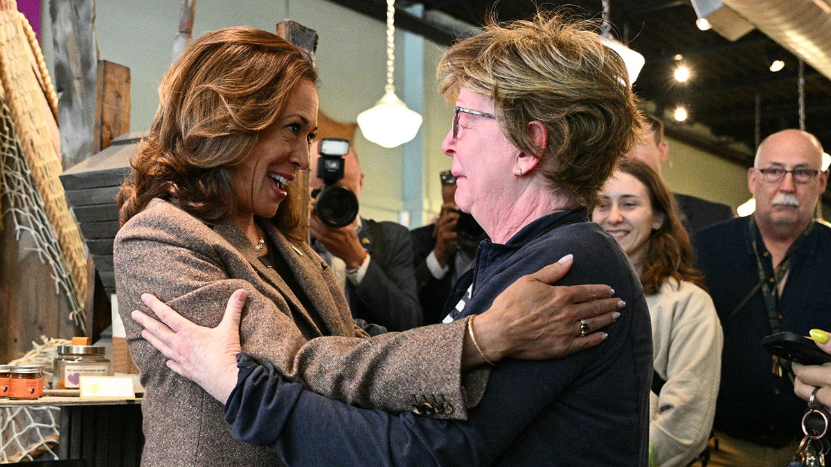 Kamala Harris abraça uma mulher chorando na loja de especiarias Penzie's