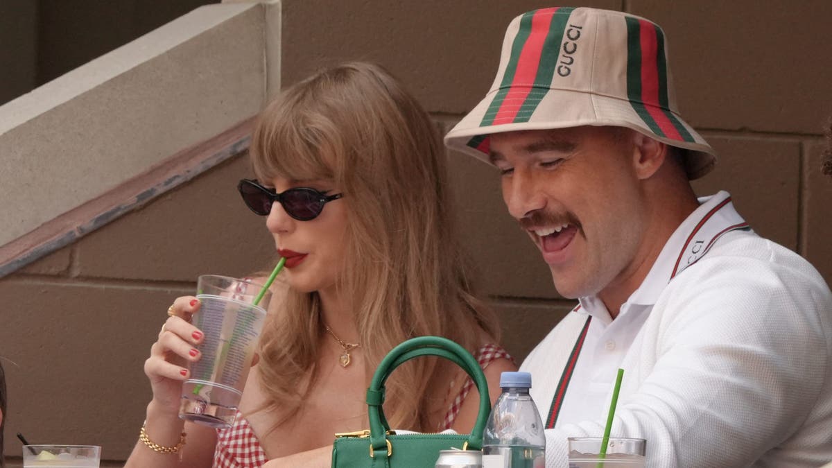 Taylor Swift takes a sip of her drink while seated next to Kansas City Chiefs tight end Travis Kelce on the final day of the U.S. Open tennis tournament, Sept. 8, 2024.