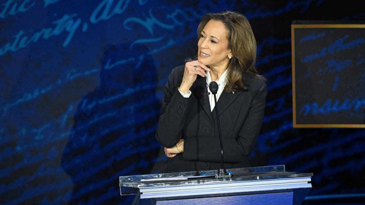 Harris touches his chin on the debate stage