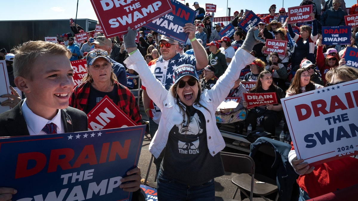 Mulher comemorando com cartaz pró-Trump