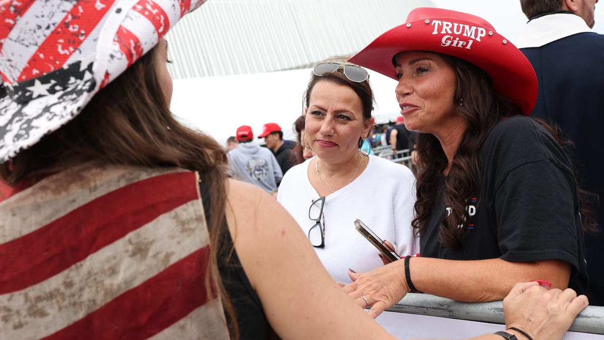 Trump supporters in cowboy hats chat outside a rally in Uniondale, NY, on Long Island