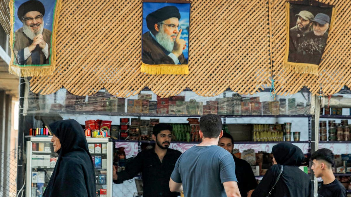 Pictures of Hassan Nasrallah, the late leader of the Lebanese Shiite terror group Hezbollah who was killed in an Israeli air strike in Beirut days earlier, hang above a stall as people shop in Damascus' Sayyida Zeinab district on Sept. 29, 2024.