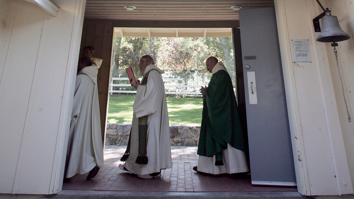 Los monjes se dirigen a la misa del mediodía a través de una brisa en la capilla de la Abadía de San Andrés, en Valyermo.