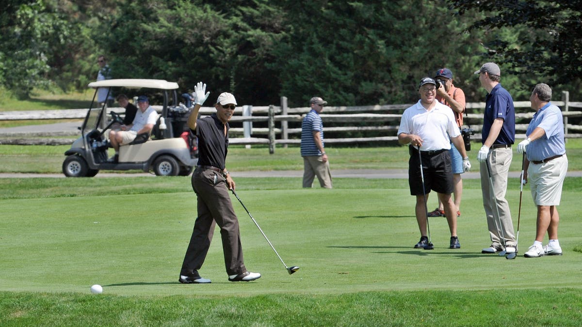 US President Barack Obama (L) plays golf