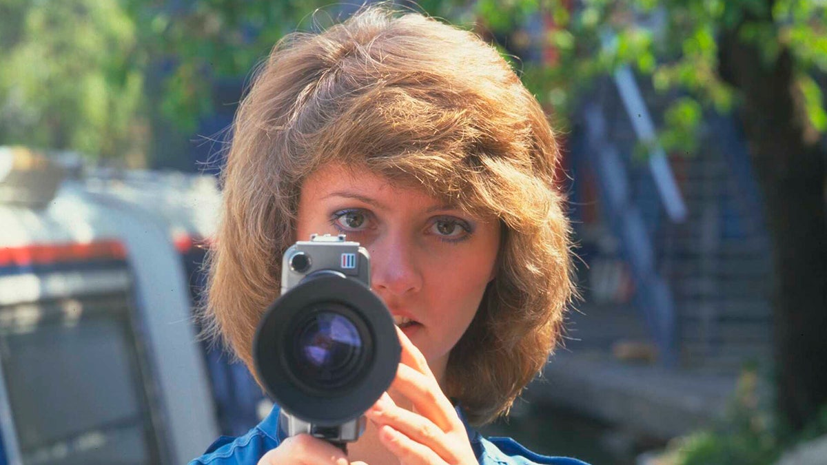 Anne Diamond holding a camera.