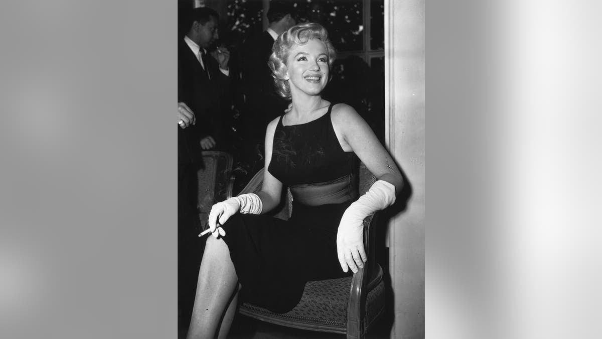 Marilyn Monroe con un vestido negro transparente y un cigarrillo en la mano.