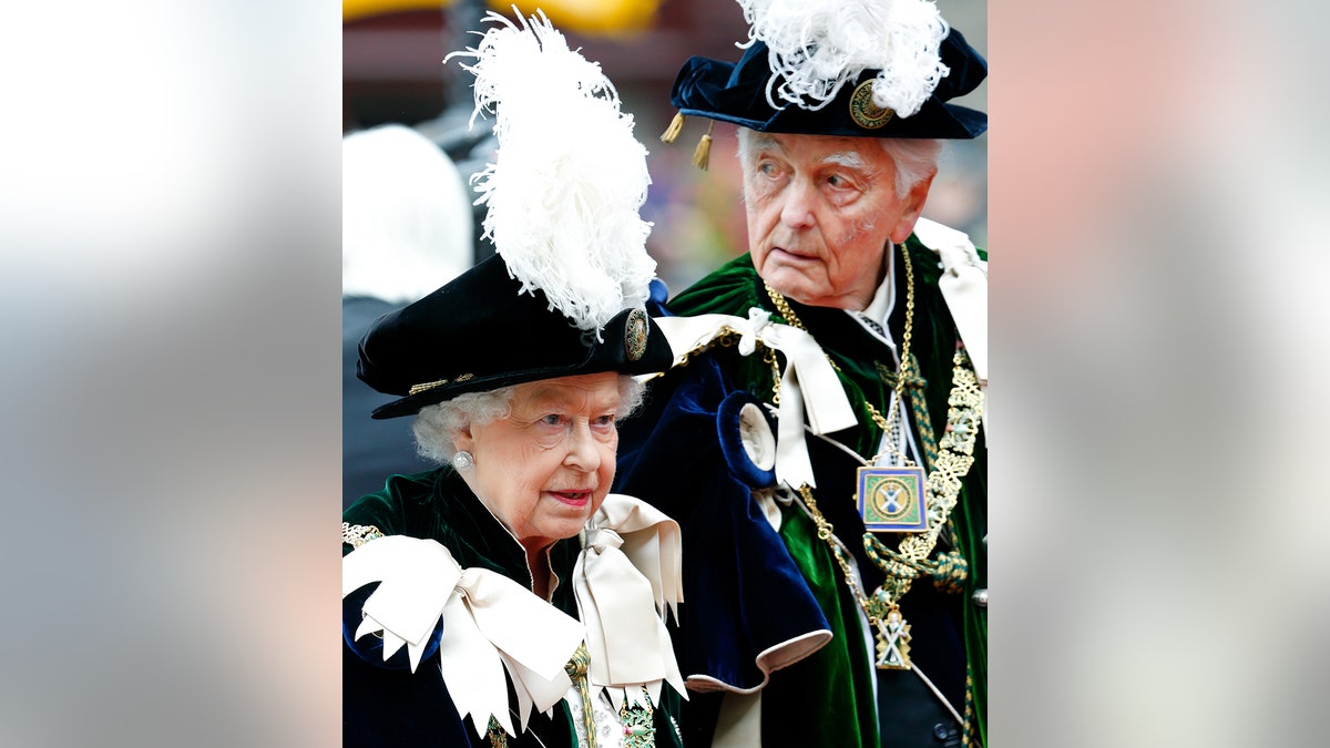 Queen Elizabeth in royal robes standing next to David Ogilvy