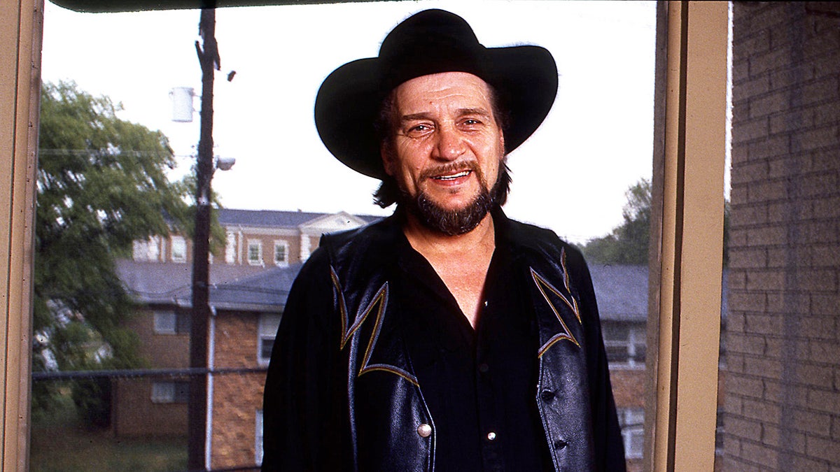 Waylon Jennings wearing all black with a country hat