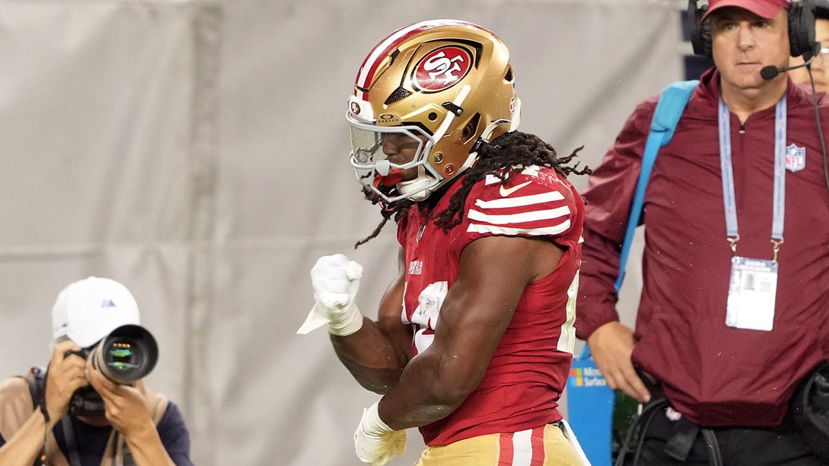 O running back do San Francisco 49ers, Jordan Mason, reage após uma corrida contra o safety do New York Jets, Chuck Clark, durante o quarto período no Levi's Stadium.