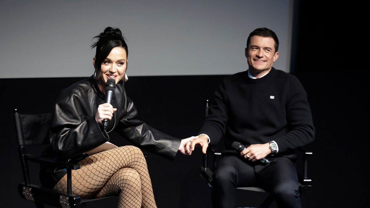 Katy Perry holds Orlando Blooms hand during an event