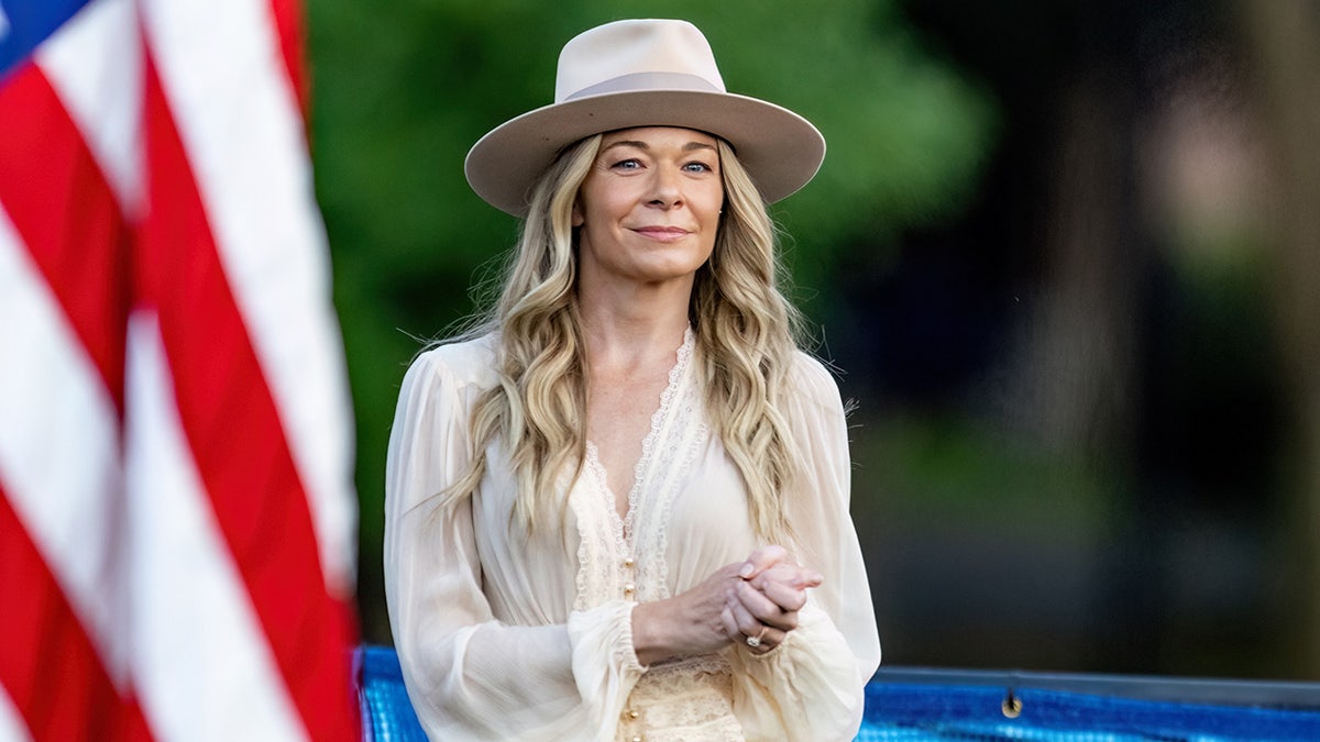 LeAnn Rimes posando delante de una bandera estadounidense