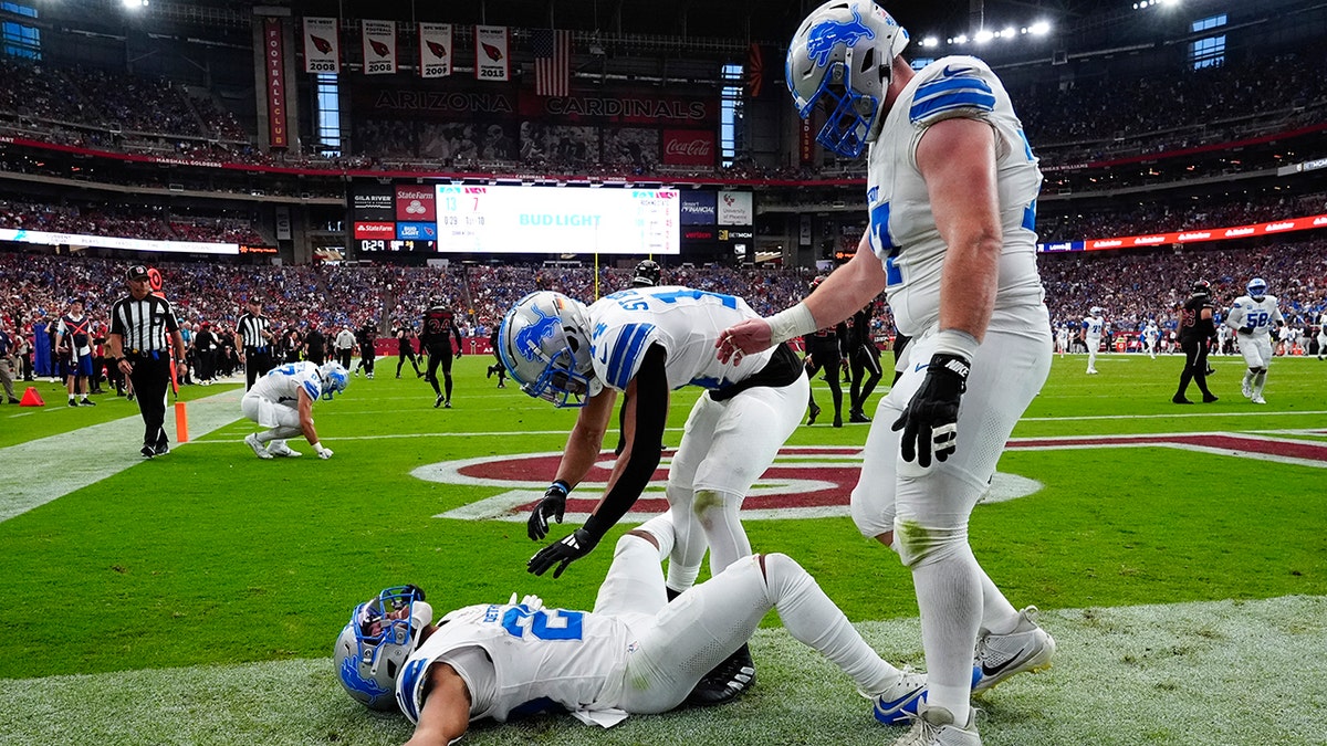 Jahmyr Gibbs lies in the end zone