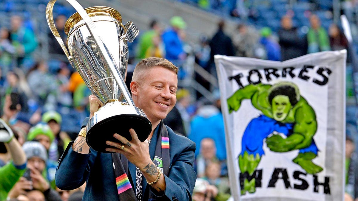 Macklemore sostiene un trofeo