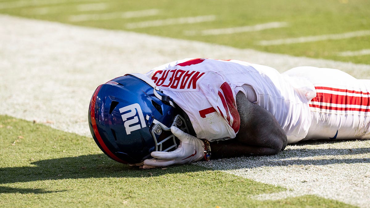 Malik Nabers laying down with hands on head