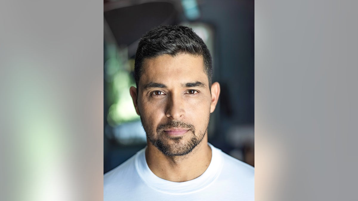 A closeup of Wilmer Valderrama in a white shirt.