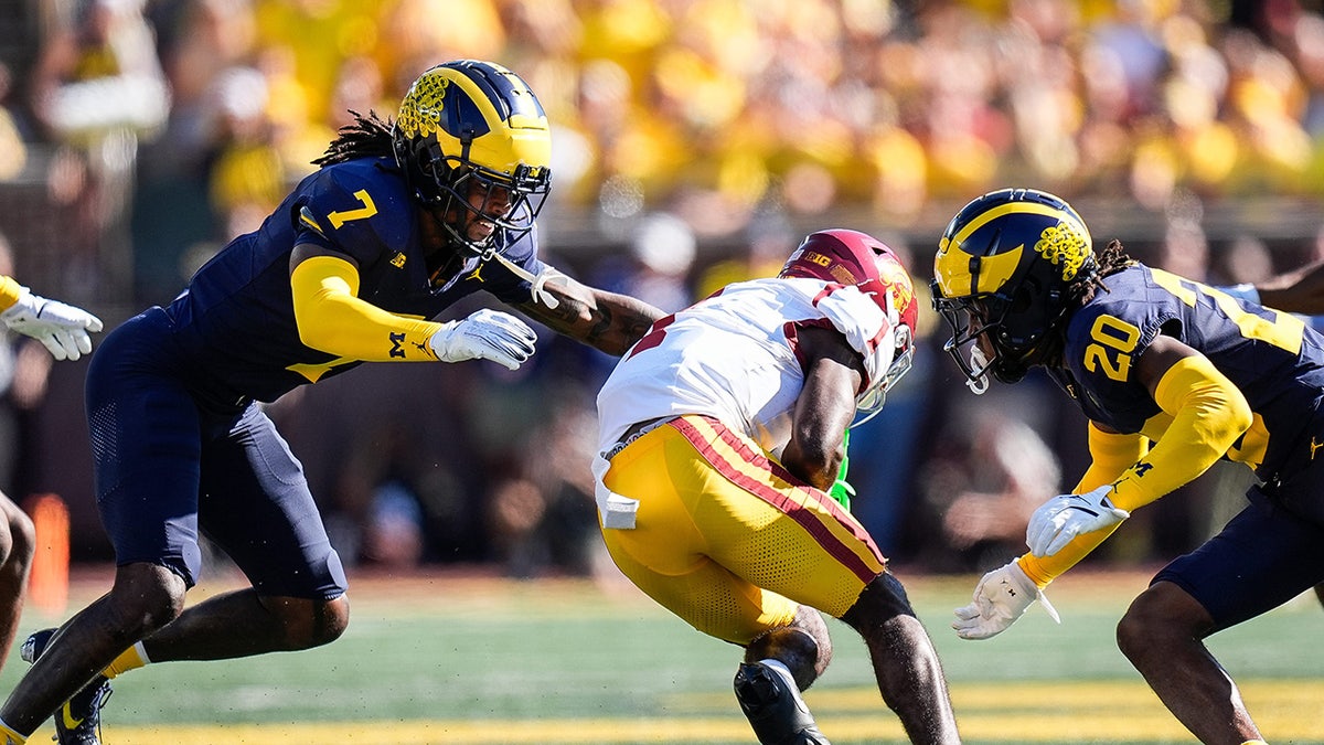 Wolverines try to tackle Trojans player