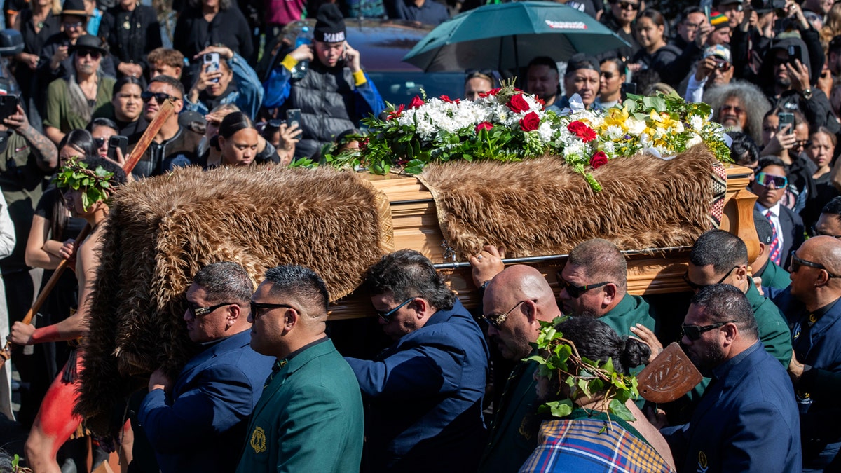 El rey maorí muerto es llevado en un ataúd para su entierro.