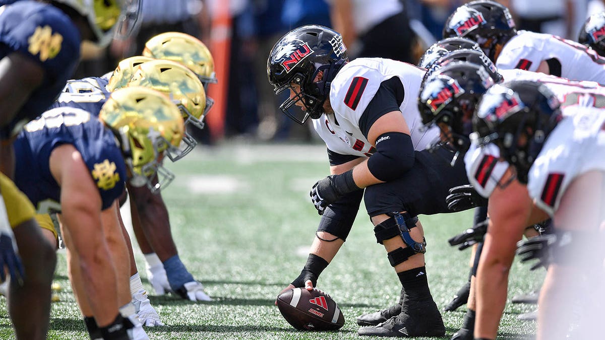 College football players line up before a snap