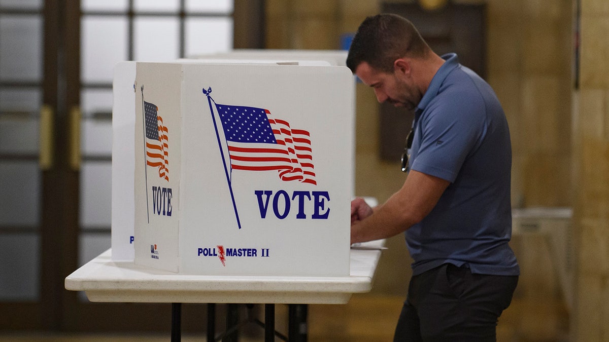 man at voting booth voting