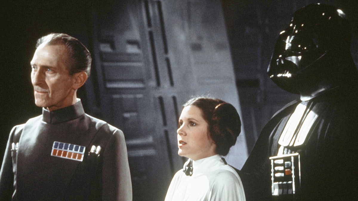 Peter Cushing, Carrie Fisher and Darth Vader in a scene from Star Wars