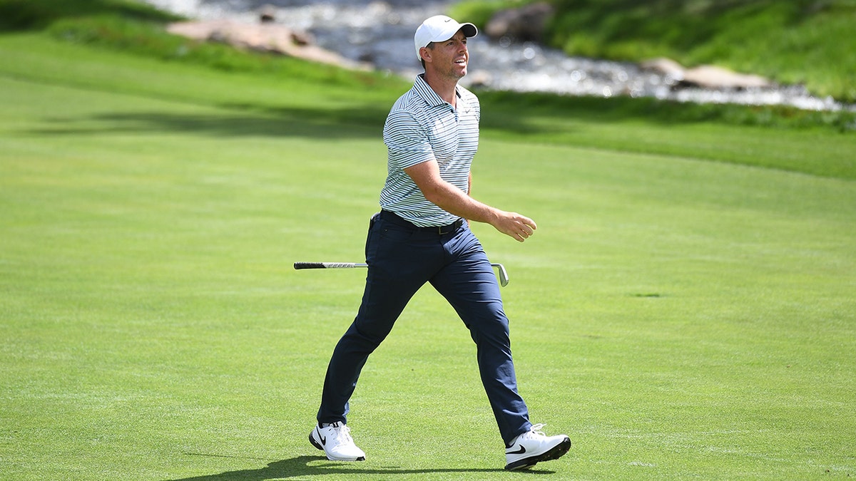 Rory McIlroy walks connected  course